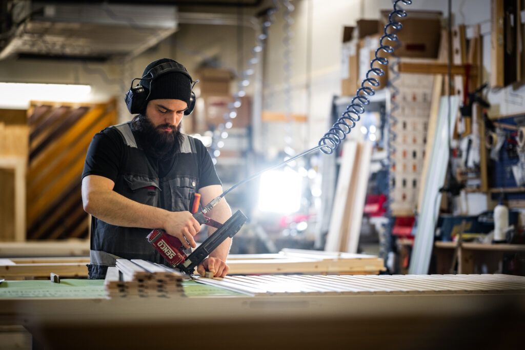 tehdastyöntekijä valmistamassa paneeliovea